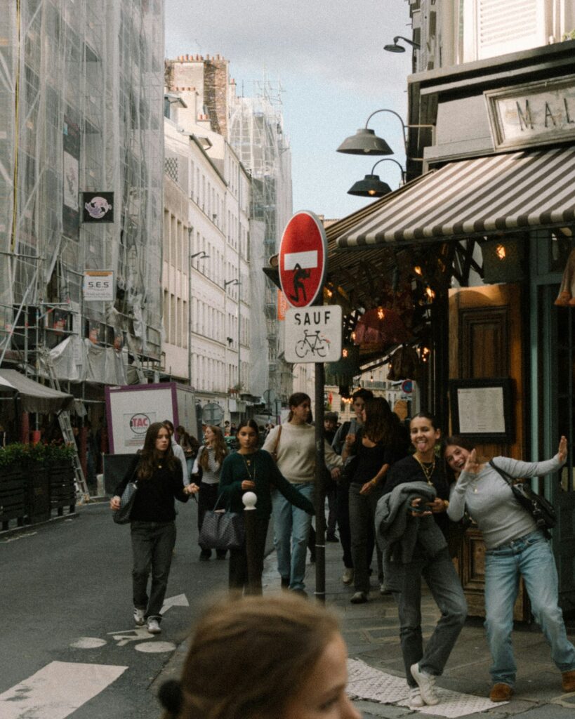 People walking past a neighborhood cafe in an international city