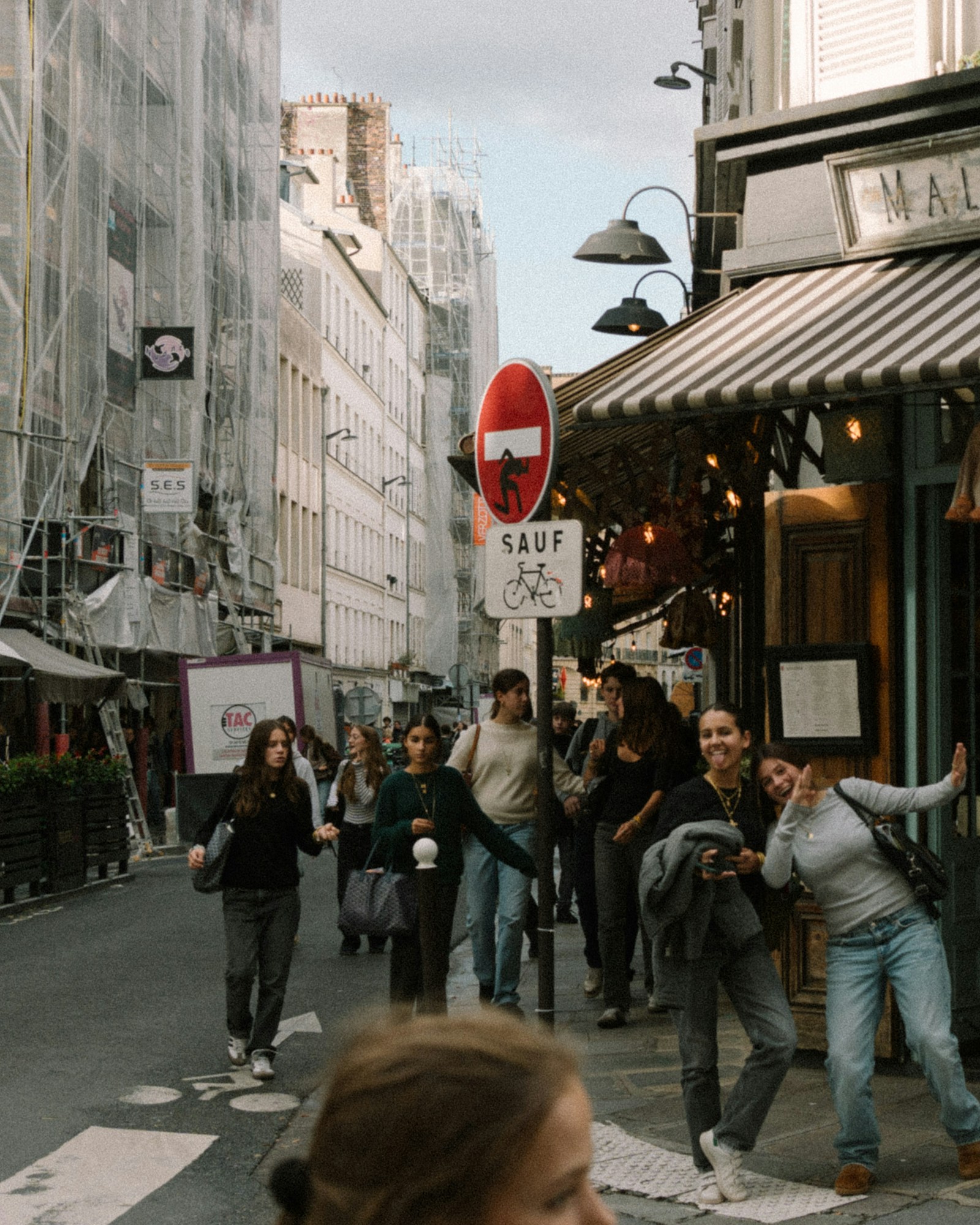 People walking past a neighborhood cafe in an international city
