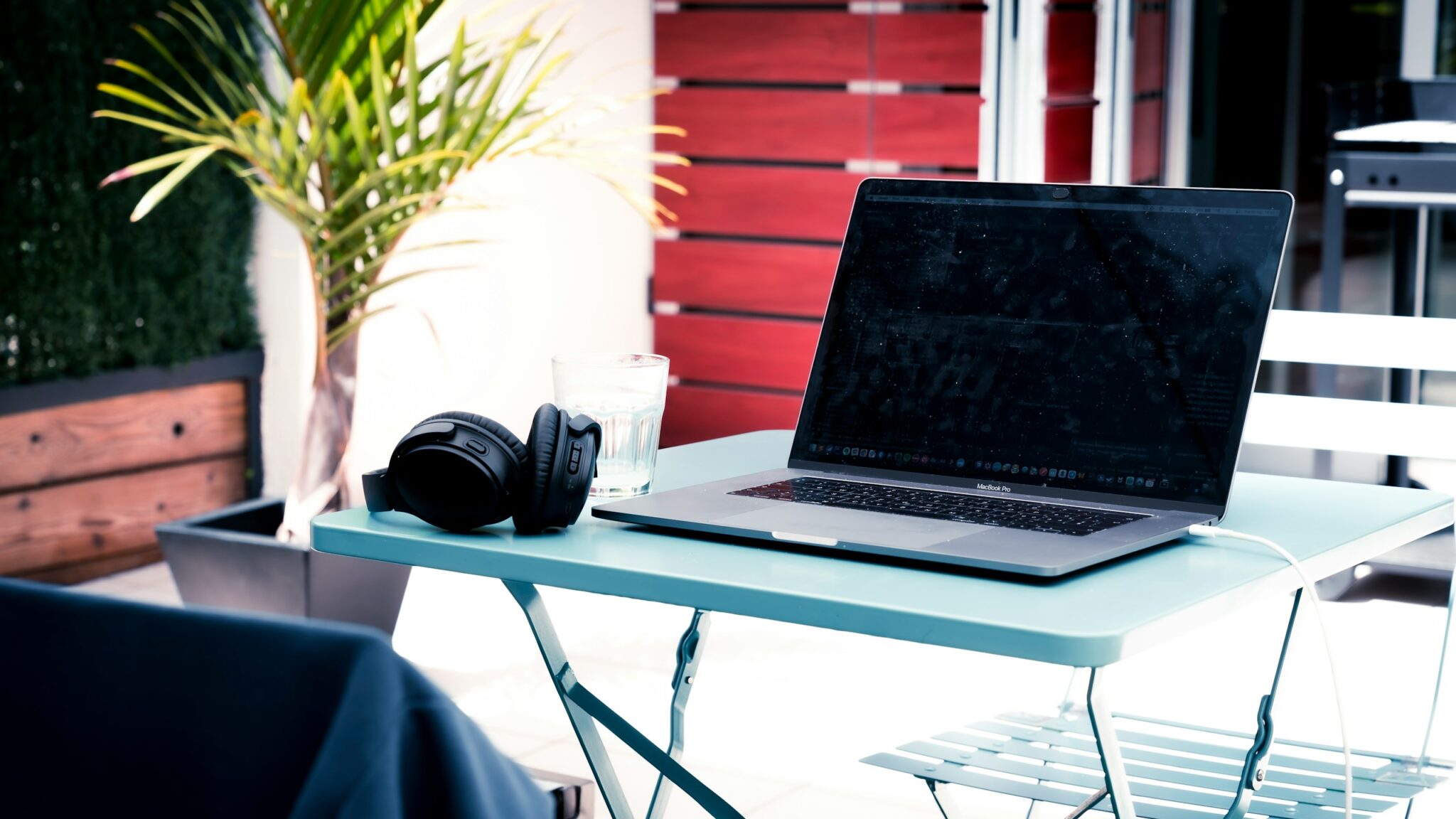 Laptop and coffee on a bright outdoor balcony workspace