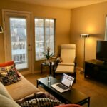 Furnished apartment living room with a laptop for a long-stay rental checklist