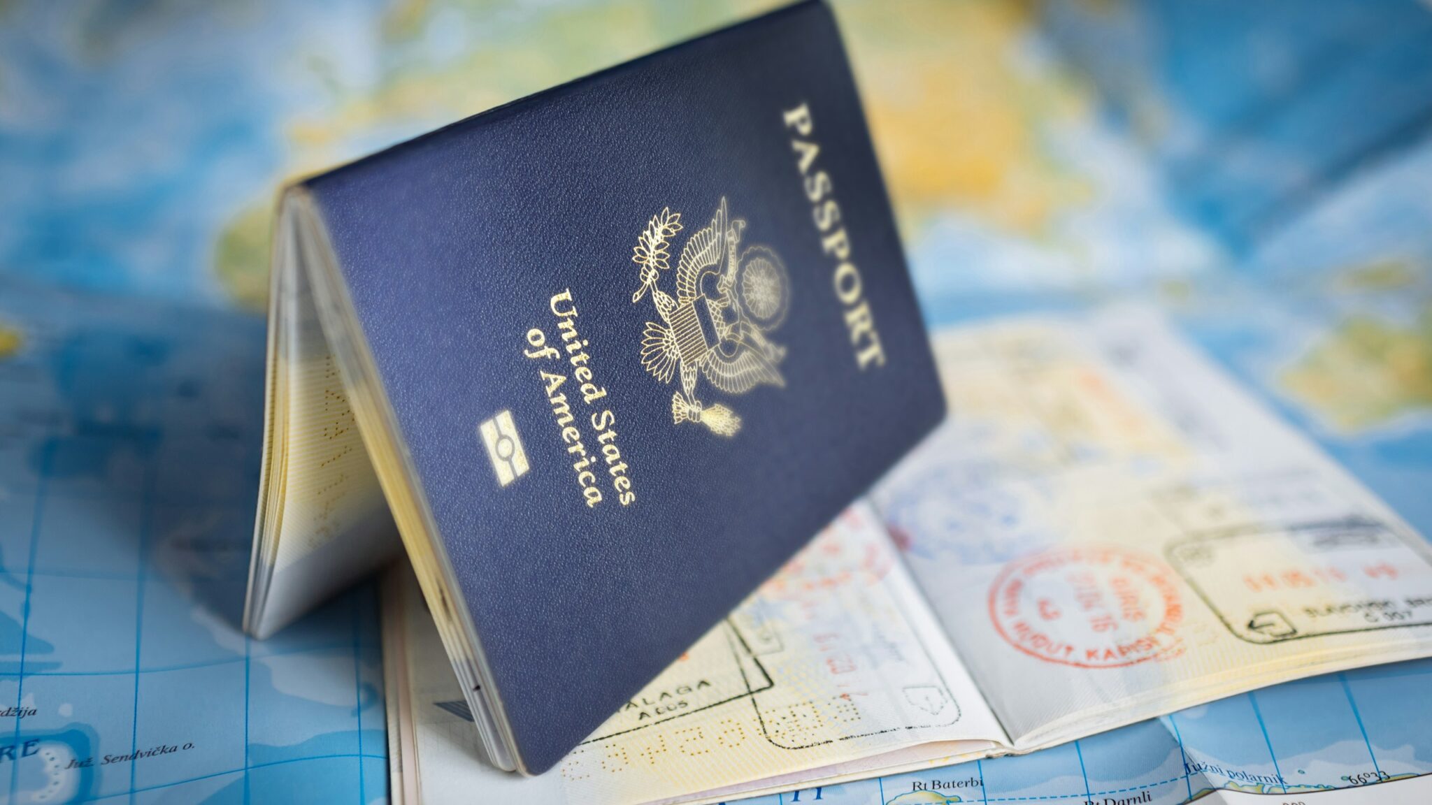 United States passport resting open on a colorful world map